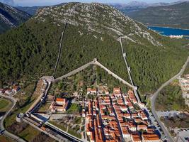 Aerial drone view of the fortified walls of the city Ston in Croatia. Tourism near the Adriatic sea. Historic visits. photo