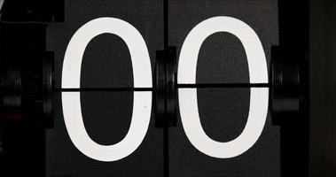Flip Uhr Jahrgang Countdown Blätter Null zu einer Weiß Zahlen auf ein schwarz Hintergrund. video