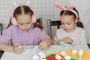 los niños decoran muñecos de huevos blancos, pegan pegatinas con diferentes emociones, estudian emociones foto