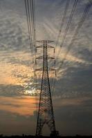 High-voltage poles are used to carry electricity for industrial plants and people to use in the farmer's fields in the evening. Beautiful sky atmosphere and designed by electrical engineers. photo