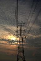 High-voltage poles are used to carry electricity for industrial plants and people to use in the farmer's fields in the evening. Beautiful sky atmosphere and designed by electrical engineers. photo