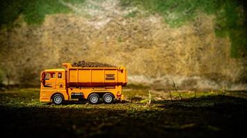 South Minahasa, Indonesia  January 2023, a yellow dump truck toy transporting sand photo