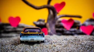 Minahasa, Indonesia  December 2022, toy car with gradient orange background and a heart photo