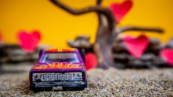 Minahasa, Indonesia  December 2022, toy car with gradient orange background and a heart photo