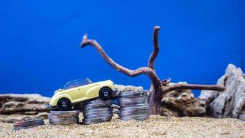 minahasa, Indonesia  January 2023, toy car on a pile of coins, saving for the future, managing successful transportation business technology concept photo