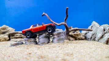 minahasa, Indonesia  January 2023, toy car on a pile of coins, saving for the future, managing successful transportation business technology concept photo