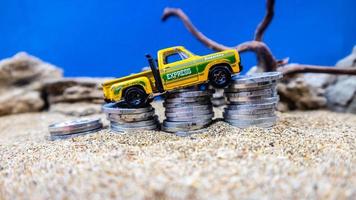 minahasa, Indonesia  January 2023, toy car on a pile of coins, saving for the future, managing successful transportation business technology concept photo