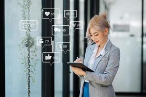 Asian woman typing smartphone, keyboard  with laptop computer of Social media and Marketing virtual icons screen concept. photo