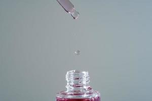 Pink face oil with glass pipette photo