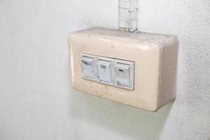 Old light switch on white wall photo