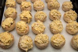 champignons stuffed with cheese and garlic on a baking sheet photo