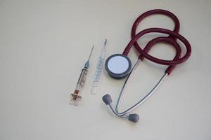 Red stethoscope and syringe photo