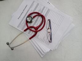 top view of the Red stethoscope and eyeglass on drug test photo