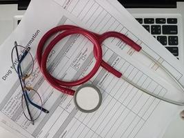 top view of the Red stethoscope and eyeglass on drug test photo