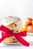 Sweet Easter cake panettone with icing and golden eggs. photo