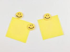 Yellow sticky note pads with yellow circle smiling faces isolated on white background. photo