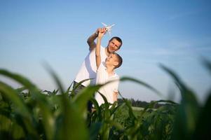 Cute boy in a cornfield with dad launching a plane photo