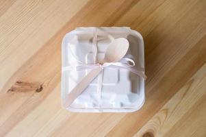 The bento cake box stands closed on a wooden table photo