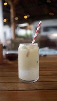 Caffe latte with a colorful straw in a medium glass in a table. photo