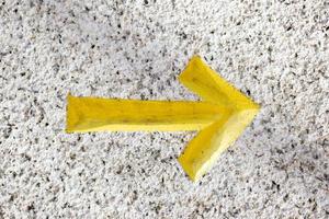 Yellow Arrow chiseled on Granite Stone background photo