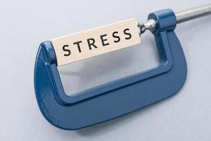 Stress concept. Wooden block with text on clamp photo