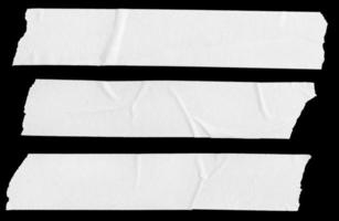 Three white Blank painter tape stickers isolated on black background photo