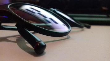 black eye glasses on the desk with reflection photo