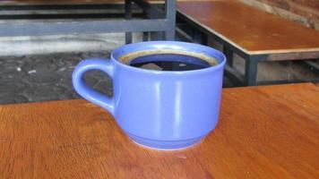 azul taza de americano café en el mesa foto