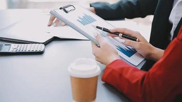 Financial analysts analyze business financial reports on a digital tablet planning investment project during a discussion at a meeting of corporate showing the results of their successful teamwork. video