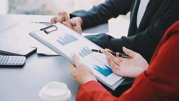 Financial analysts analyze business financial reports on a digital tablet planning investment project during a discussion at a meeting of corporate showing the results of their successful teamwork. video