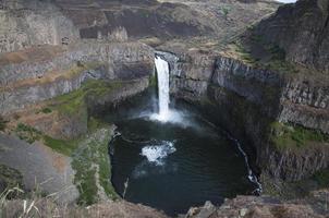 Waterfall created by river in the canyon falling to the deep pond photo