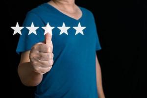 a businessman thumbs up on the five star to give satisfaction in service.rating very impressed.Customer service and Satisfaction concept. photo