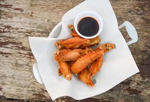 frito pollo alas con salsa tailandés comida en de madera mesa comida antecedentes foto