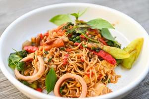 noodles plate with instant noodles stir fried with vegetables herb spicy tasty appetizing asian noodles mix seafood stir fried squid with basil and chilli pepper photo