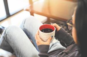 Morning relaxation girl sitting and enjoying coffee leisure time happy woman relaxing in home on winter, Woman relaxing at home and sitting on sofa and looking drinking coffee photo