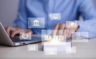 Concept of tax payment optimisation business finance,Man using calculator and taxes icon on technology screen,income tax and property, background for business, individuals and corporations such as VAT photo