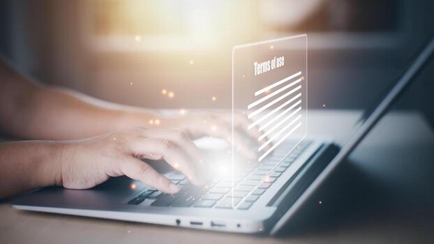 Man using a laptop with a graph of Terms of use concept, online banking check budget planning concept banner for website header design,Terms of use business concept. Terms and conditions of contract. photo