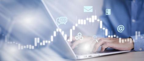 businessman hand type on the laptop of company profit with colleagues partner explain with virtual dashboard statistic chart stock infographic, graphs, cryptocurrency, and new trading platforms photo