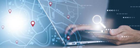 Man using laptop with virtual world and model map with location point , GPS app, icon Travel maps and find places in the online system, all screen graphics are generated,Searching for travel. photo