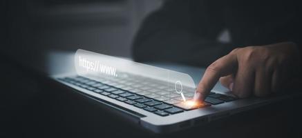 Hand  type laptop and Searching Browsing Internet Data Information with blank search bar. man's hands are using smartphone and keyboard to Searching for information. Using Search Console with website. photo