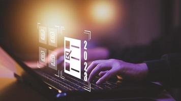 Hand using laptop and 2023 with folder of document Management System, online documentation database and process automation to efficiently manage files work, knowledge, Corporate business technology, photo