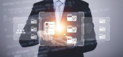 Businessman hand touch folder of document Management System,  online documentation database and process automation to efficiently manage files work, knowledge, Corporate business technology. photo