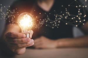 Innovative technology in science and communication concepts, and Creativity with glowing light bulbs.Hand hold light bulb with new idea concept with innovation, the new idea with energy and power photo