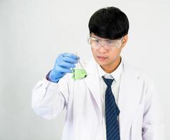 asiático hombre estudiante científico o médico en reactivo mezcla laboratorio en un Ciencias investigación laboratorio con prueba tubos de varios tamaños en el piso en laboratorio química laboratorio blanco antecedentes. foto