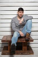 Handsome man sitting on a wooden table photo