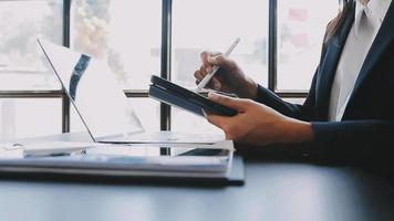 Financial analysts analyze business financial reports on a digital tablet planning investment project during a discussion at a meeting of corporate showing the results of their successful teamwork. video