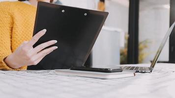 Asian Business woman using calculator and laptop for doing math finance on an office desk, tax, report, accounting, statistics, and analytical research concept video