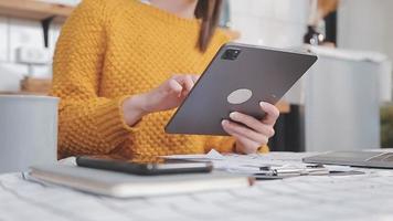 Asian Business woman using calculator and laptop for doing math finance on an office desk, tax, report, accounting, statistics, and analytical research concept video