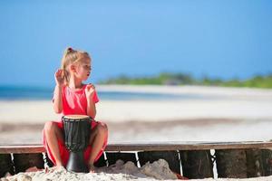 Little girl with drums on the beach photo