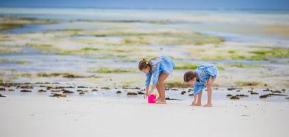 pequeño muchachas jugando en el playa foto